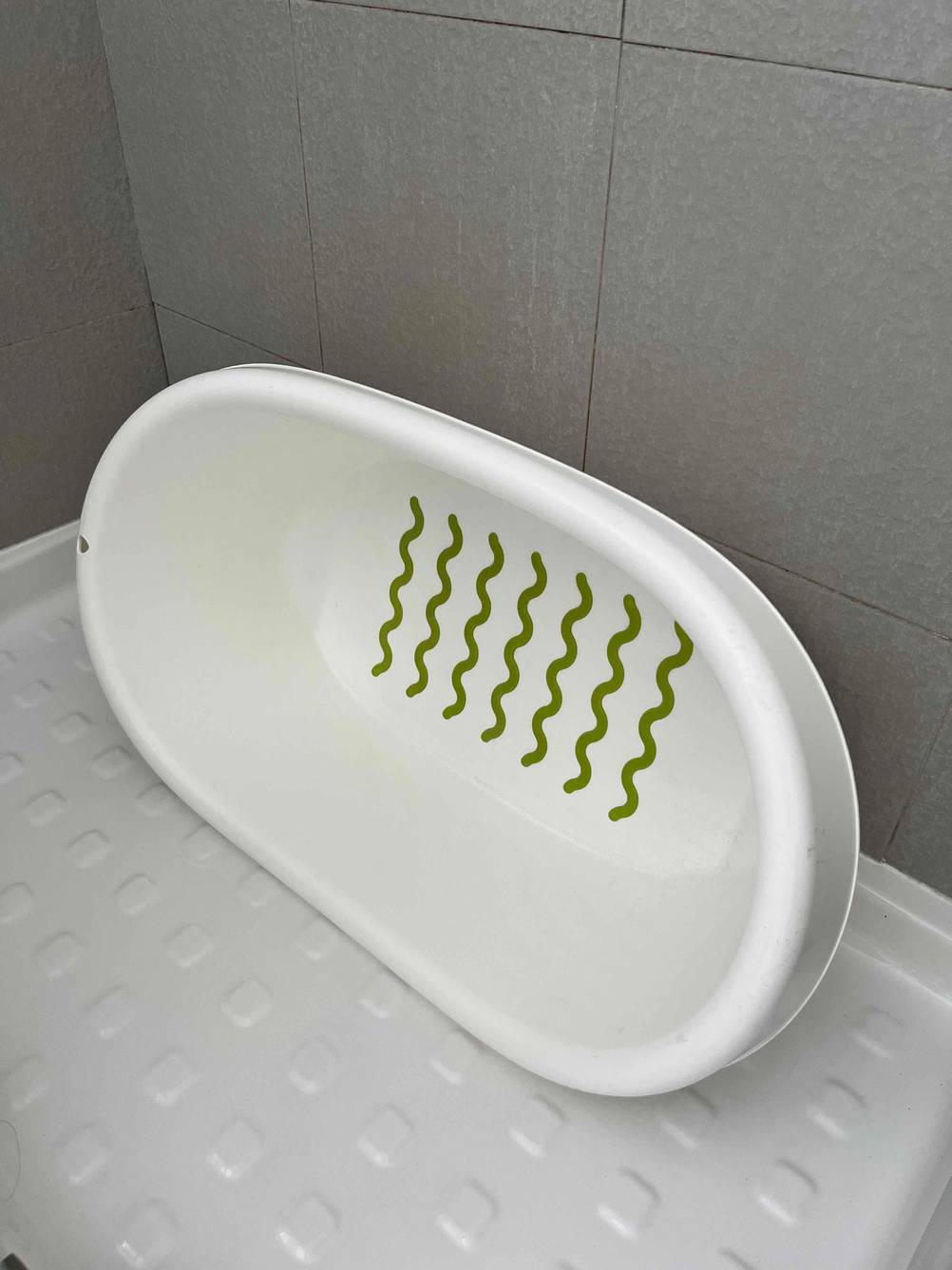 Babybadewanne im Test: eine weiße Babybadewanne ist an einer Duschwand angelehnt.