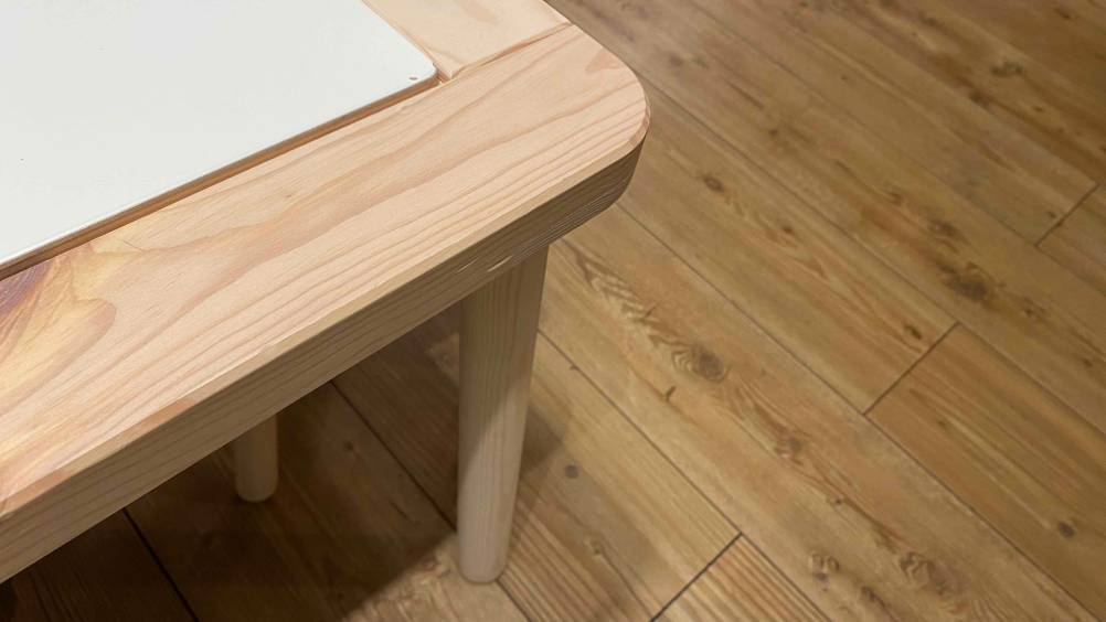 Kindertisch getestet: Ein Kindertisch aus Holz und davon die abgerundete Ecke im Fokus.