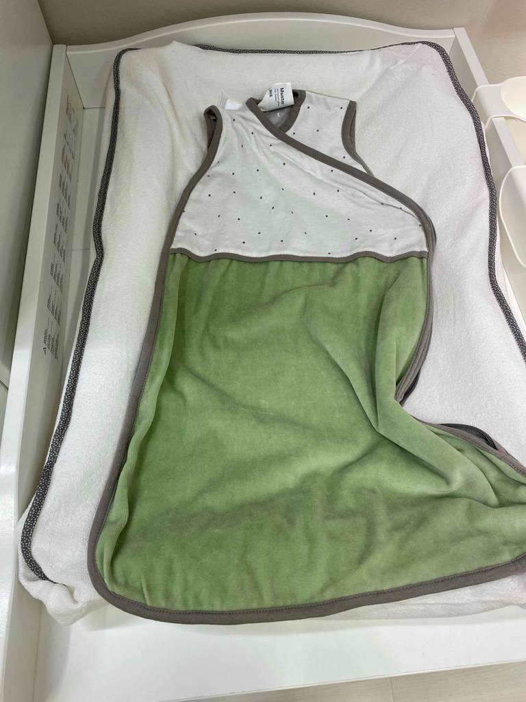 Babyschlafsack in Bett.