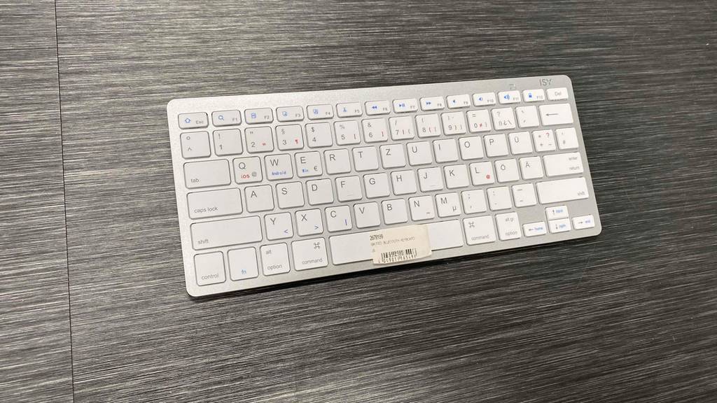 Auf einer Holzoberfläche liegt eine getestete Bluetooth-Tastatur.