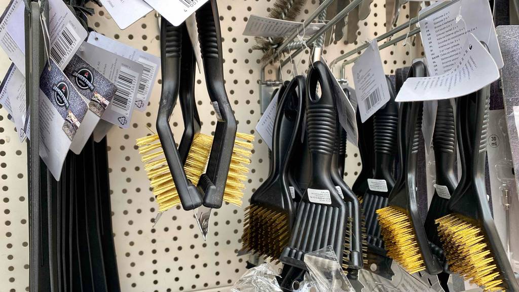Grillbürste-Messing-Test: mehrere Grillbürsten hängend in einem Regal.