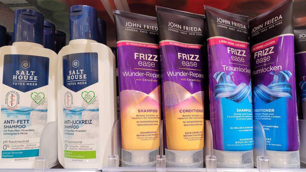 Test: John-Frieda-Shampoos befinden sich in einem Regal neben Conditioner der Marke.