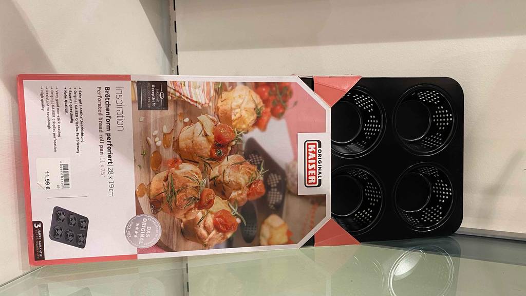 Eine getestete Brötchen-Backform in Verpackung horizontal auf einer hellen Fläche.