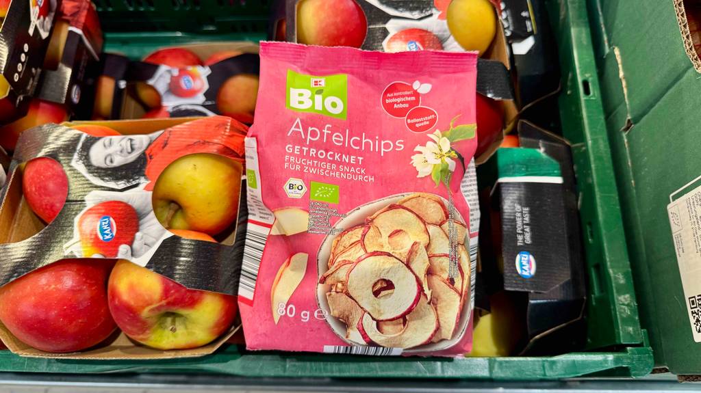 Eine getestete Packung Apfelchips liegt auf frischen Äpfeln.