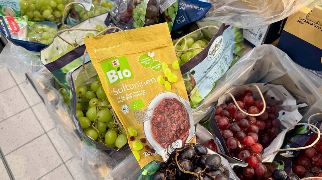 Test: Eine Packung Sultaninen liegen auf Weintrauben.