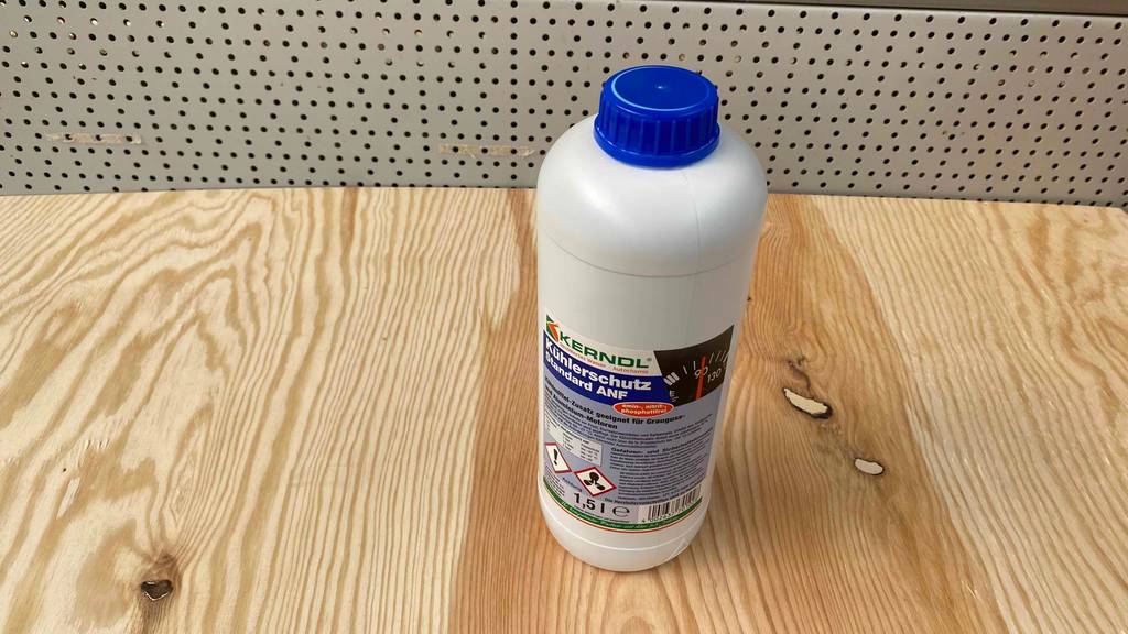 Auf einer Holzoberfläche steht eine Flasche getesteter Kühlerfrostschutz