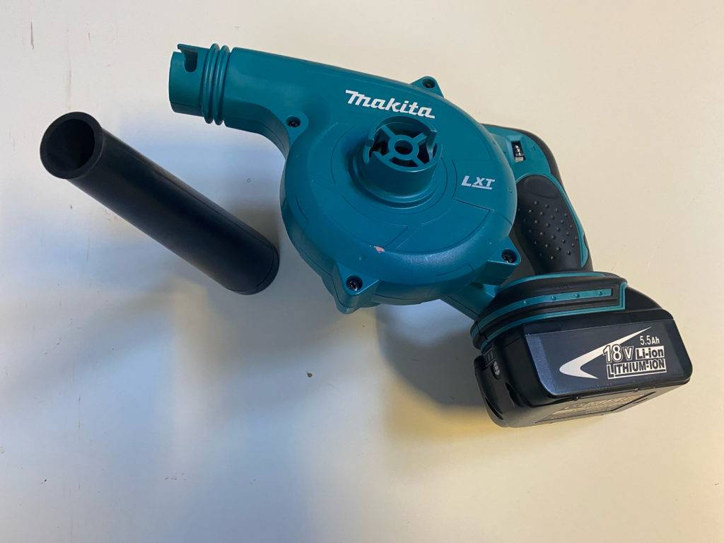 Makita-Laubbläser im Test: ein Makita-Laubbläser mit schwarzem rohr neben dem Gerät platziert.