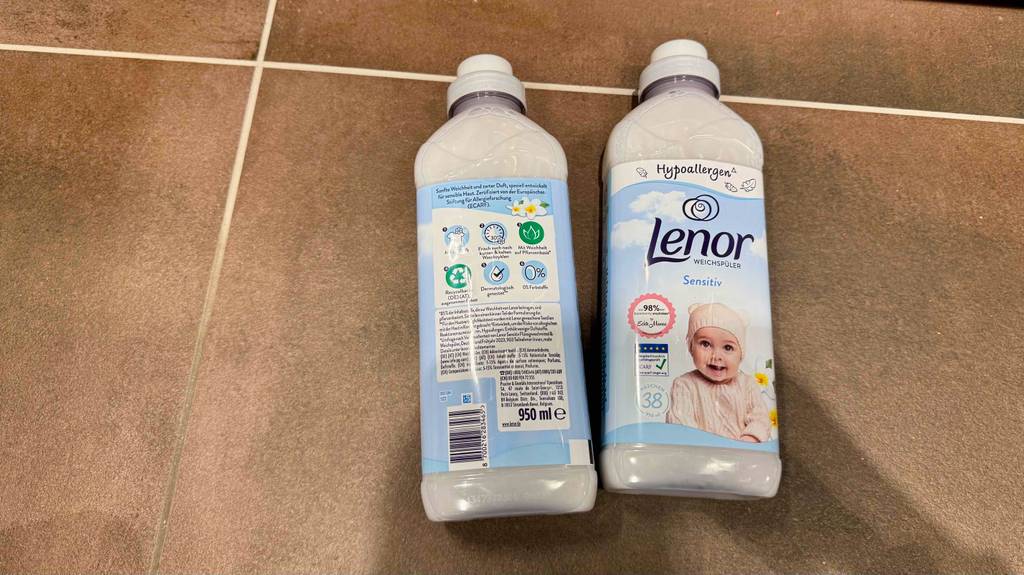 Liegende Verpackungen: Vorder- und Rückseite der getesteten Lenor-Weichspüler ersichtlich.