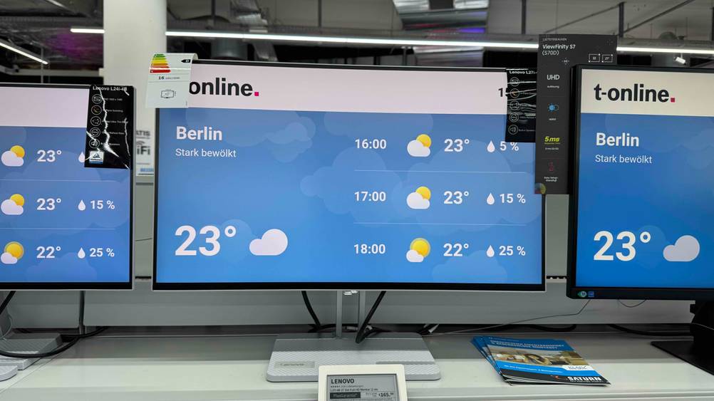Lenovo-Monitor (27 Zoll) Test: Mehrere Lenovo-Monitore sind nebeneinander ausgestellt, während die Wettervorhersage am Bildschirm ersichtlich ist.