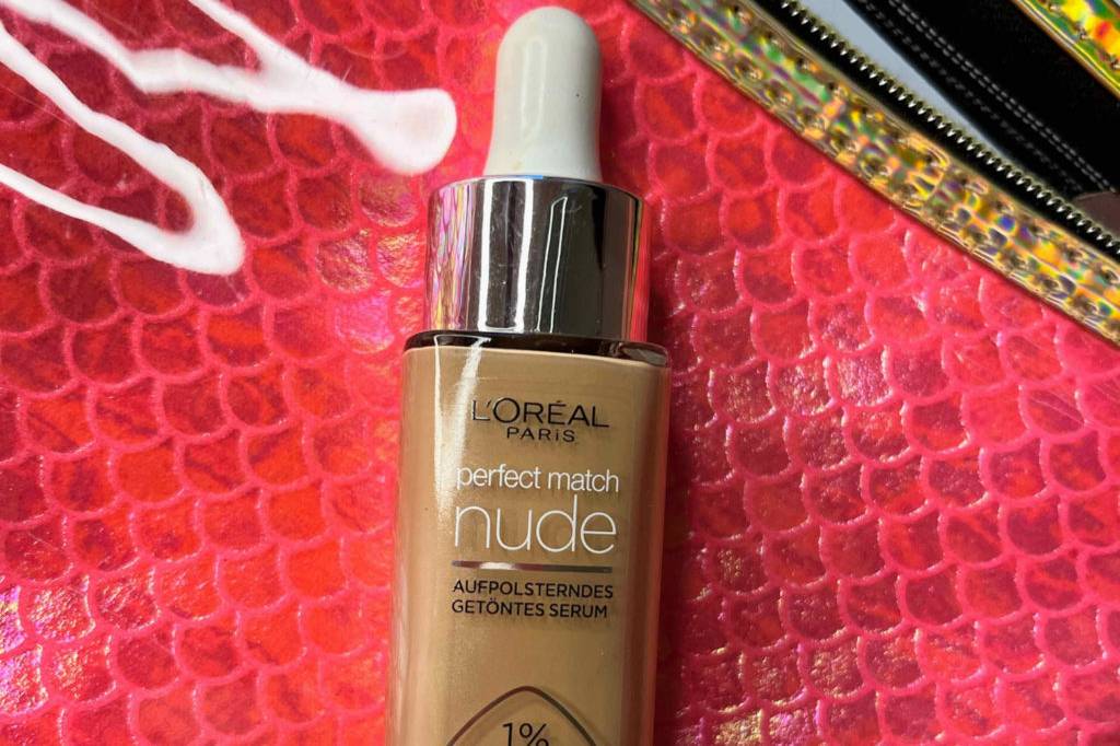 Make-up im Test: Eine Flasche Make-up auf einer roten Kosmetiktasche liegend