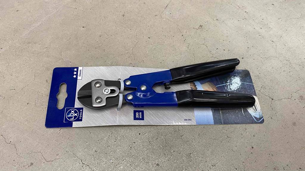 Getesteter Bolzenschneider liegt auf steiniger Oberfläche