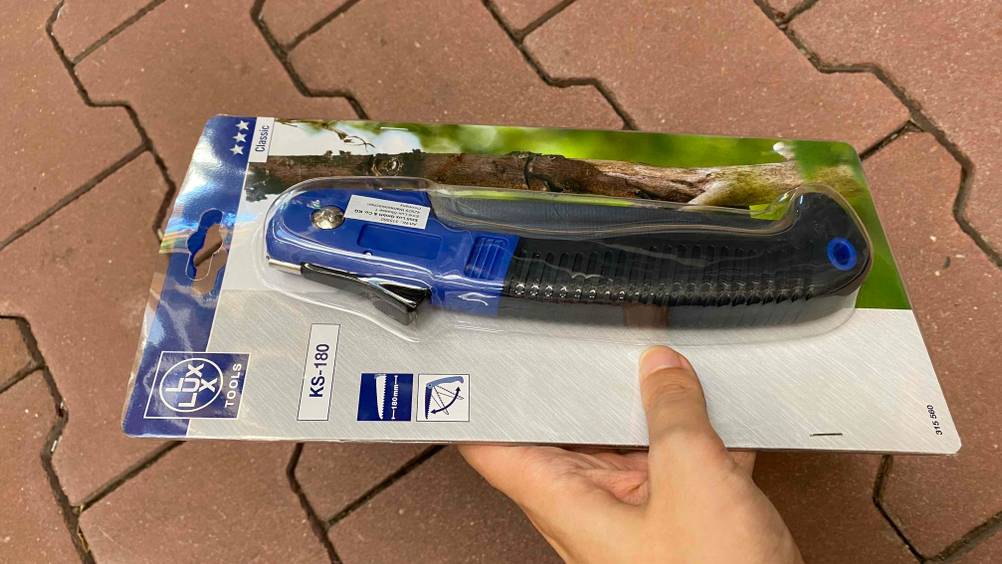 Klappsäge-Test: Eine Klappsäge in Originalverpackung wird in der Hand gehalten.