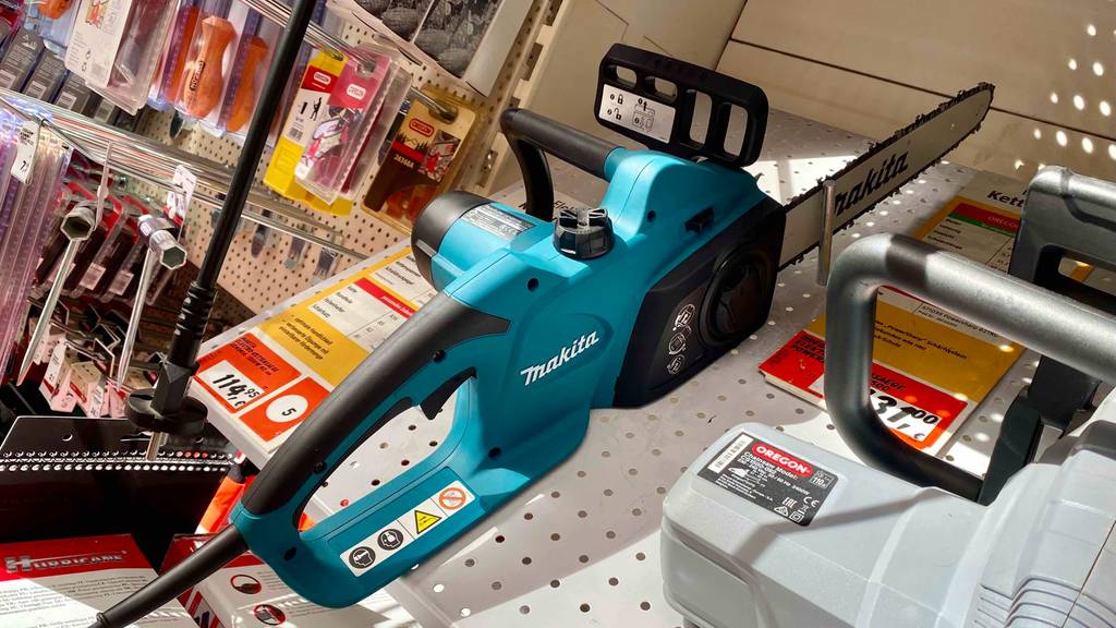 Makita-Kettensäge getestet: eine Makita-Kettensäge steht in einem Regal mit Hinweisen zum Produkt am Griff des Geräts ersichtlich.