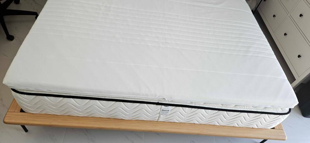 Topper-180x200 im Test: ein weißer Topper auf einem Bett.