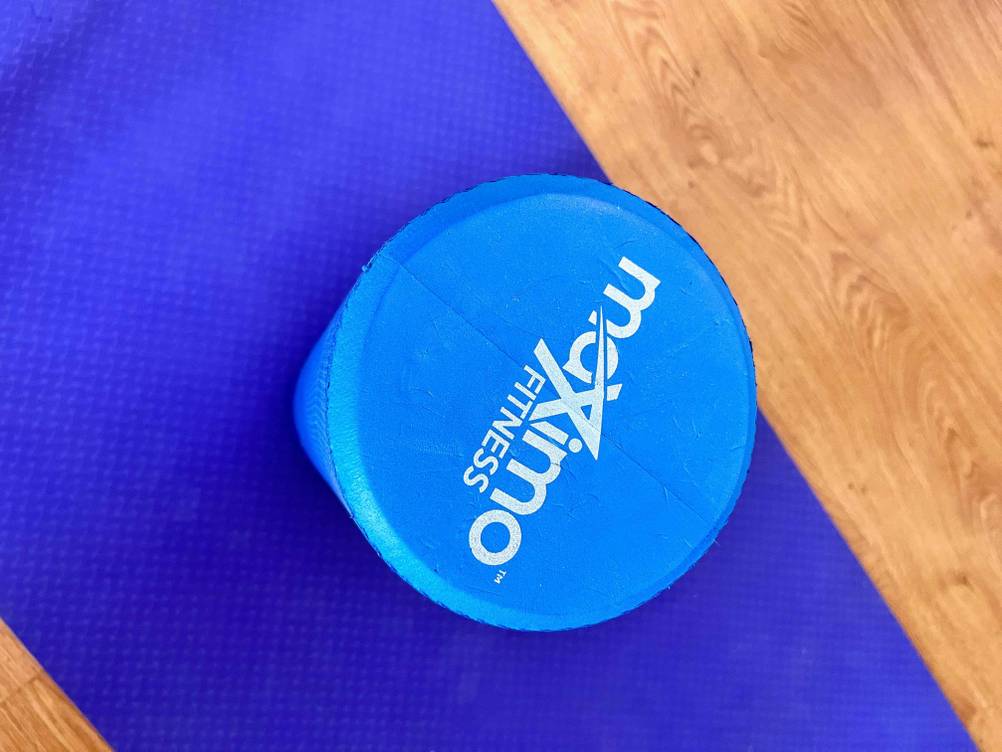 Massageroller getestet: ein blauer Massageroller stehend auf einer blauen Matte mit Markenaufschrift darauf ersichtlich.