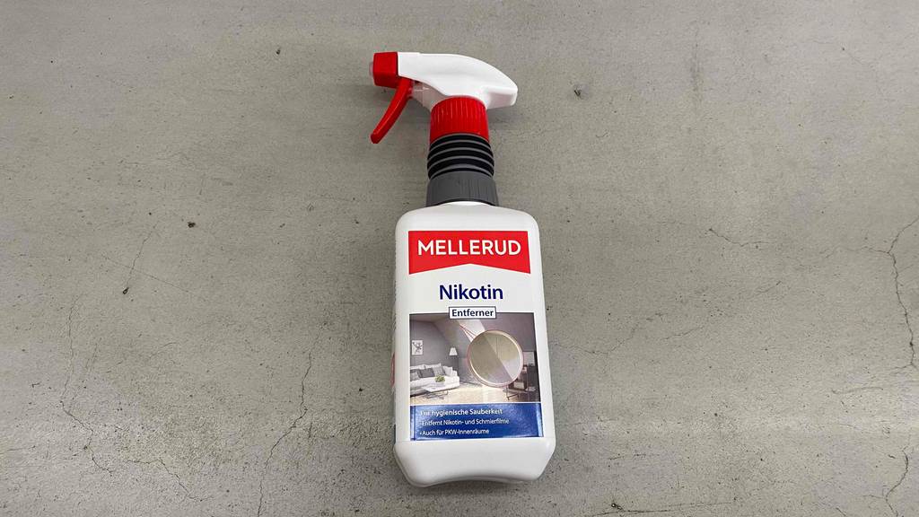 Getesteter Mellerud-Nikotinentferner in 500-ml-Sprühflasche liegt auf grauem Boden.