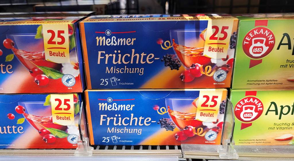 Mehrere Packungen des getesteten Meßmer-Früchtetees stehen in einem Regal.