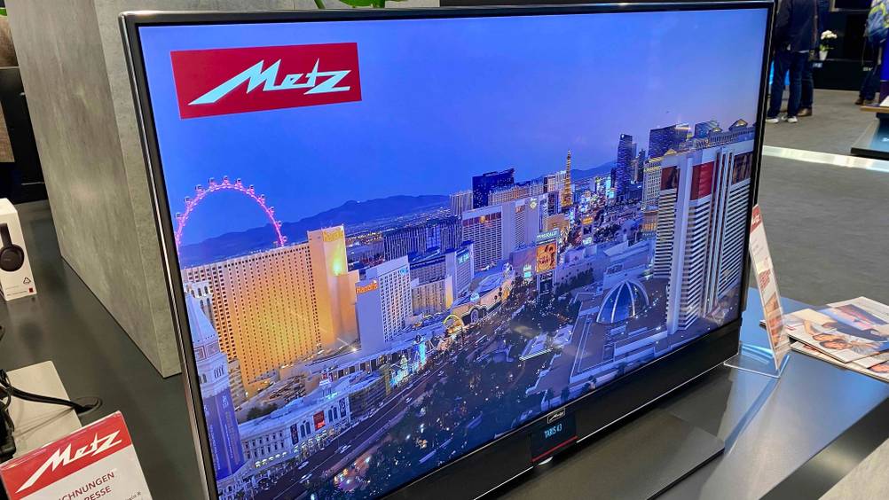 Ein eingeschalteter 43-Zoll-Fernseher auf grauem Untergrund.