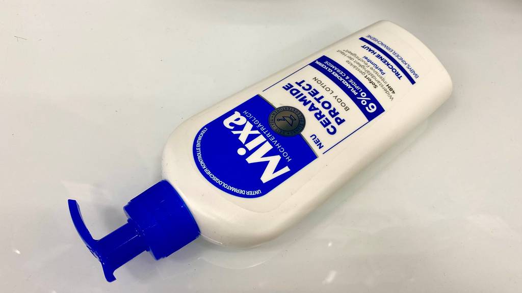 Mixa Bodylotion getestet: Eine Flasche Lotion liegt quer auf einer hellen Oberfläche