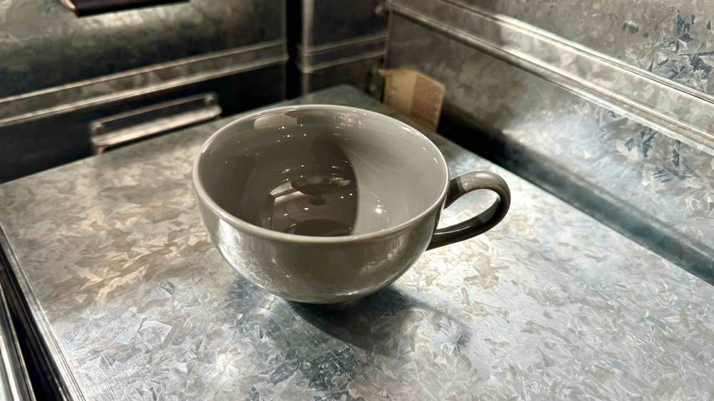 Eine getestete Teetasse steht auf einer Fläche, wobei man in das Innere der Tasse sieht.