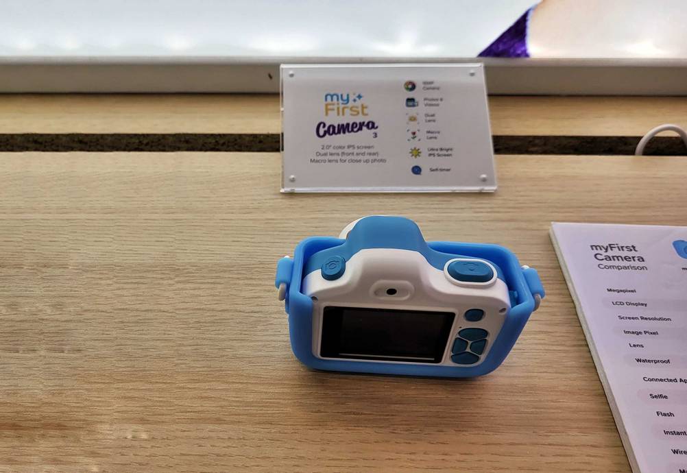 Rückseite einer getesteten Kinderkamera von schräg oben auf einer Holzfläche.