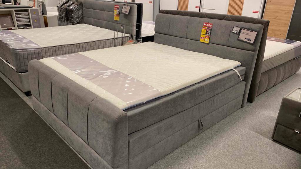 Im Test: ein Boxspringbett-180x200 stehend in einem Geschäft neben anderen Betten.