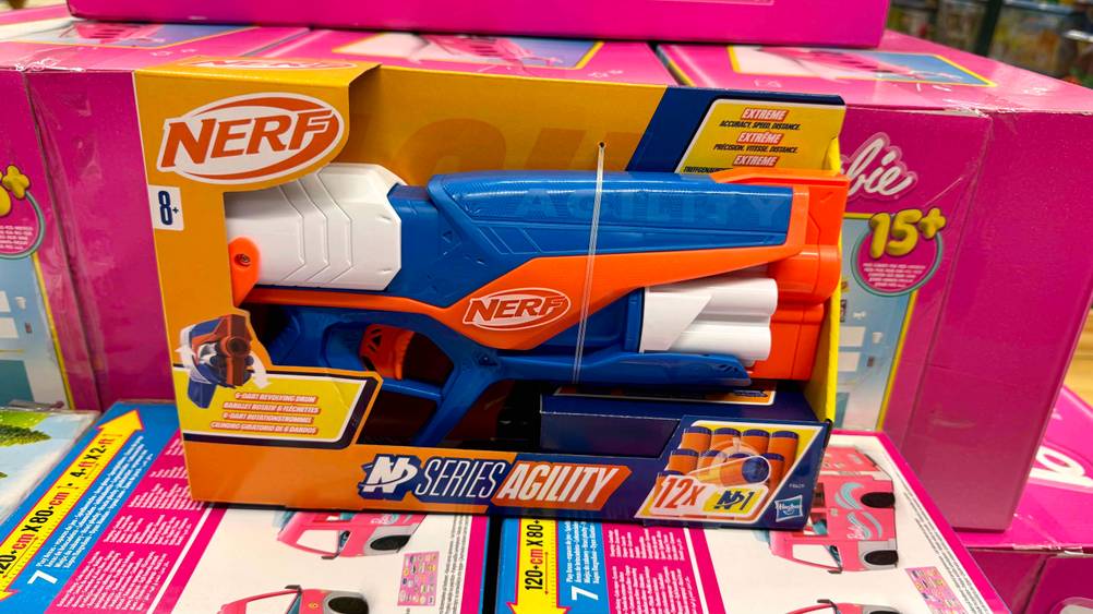 Die getestete Nerf-Blaster befindet sich noch in der Verpackung und ist vor einem Barbie-Karton platziert.
