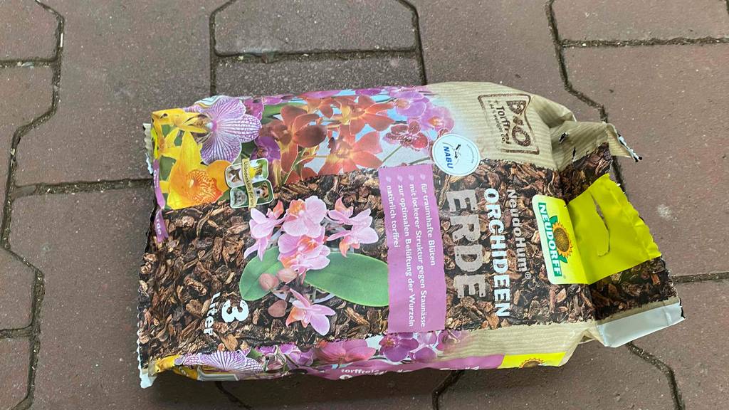 Orchideenerde im Test: Orchideenerde liegt verpackt auf einem Steinboden