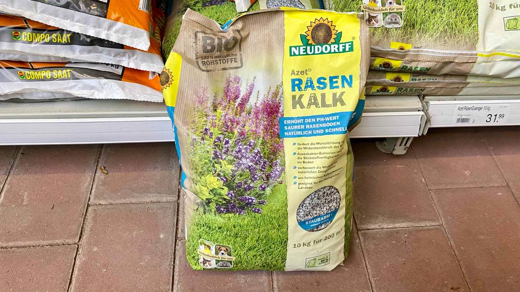 Rasenkalk im Test: ein Sack Rasenkalk steht vor einem Regal.