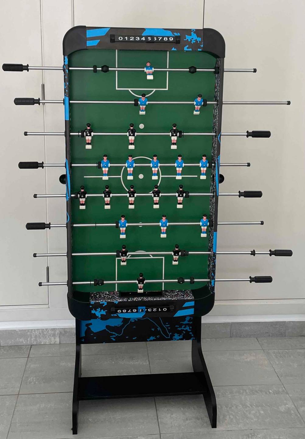 Ein getesteter Tischkicker zusammengeklappt von vorne vor einer Wand.