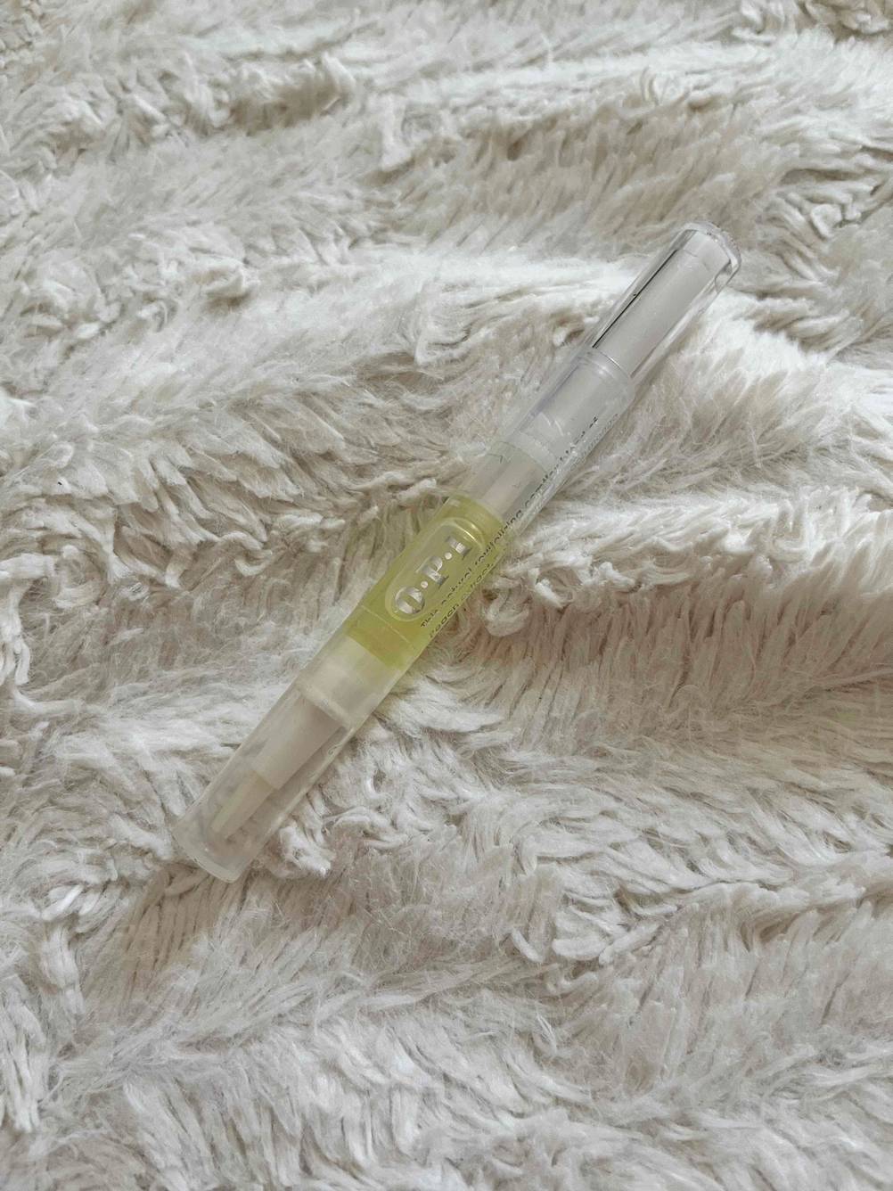 Nagelöl im Test: Ein Stift mit Nagelöl liegt auf einem hellen Stoff
