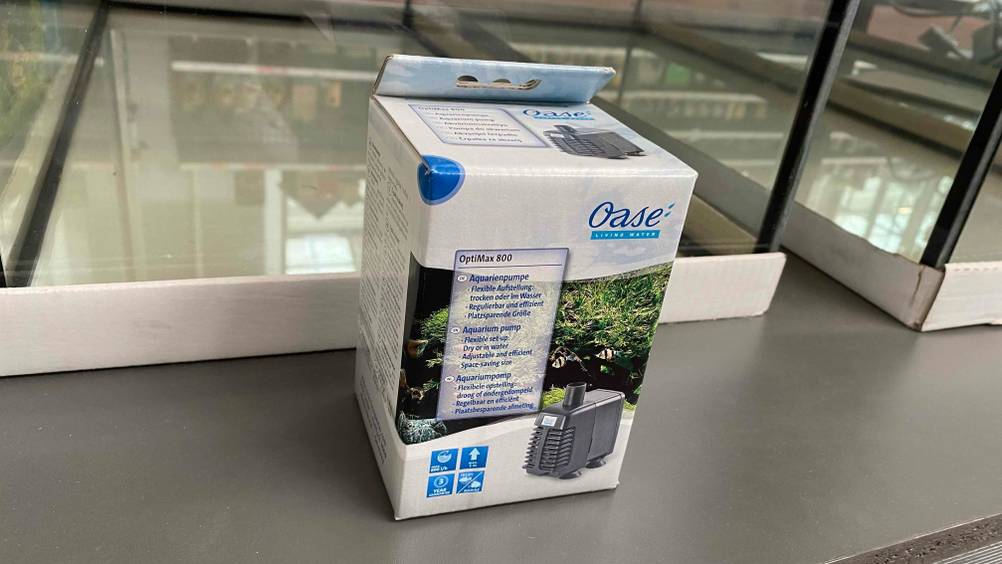 Auf einer grauen Fläche steht eine Aquarium-Pumpe in Verpackung.