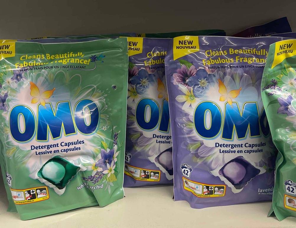 Mehrere Verpackungen des getesteten Omo-Waschmittels stehen in einem Regal.