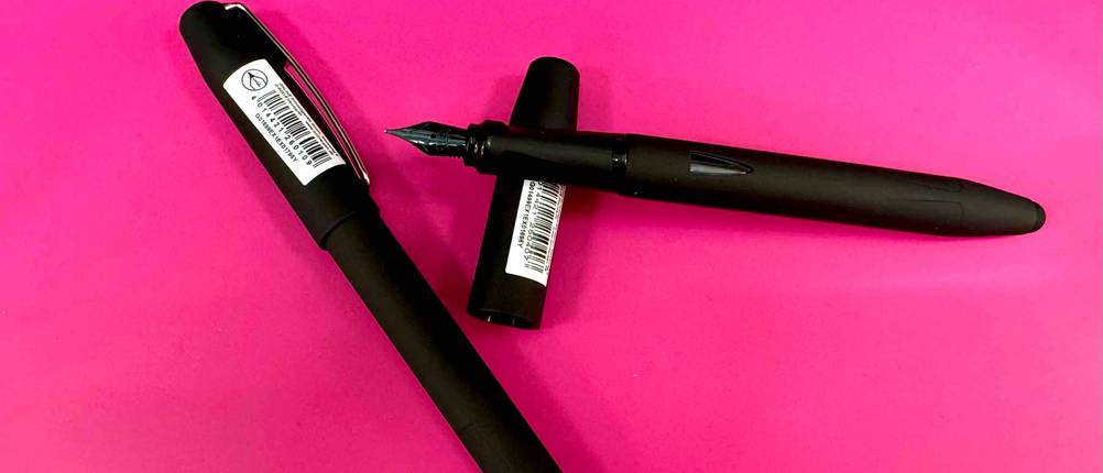 Kolbenfüller-Test: Zwei schwarze Kolbenfüllers, einer geschlossen, einer liegt auf der Kappe und hat eine schwarze Feder.