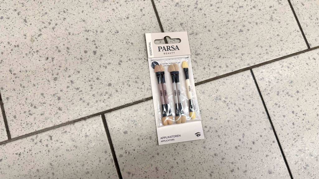 Getestete Lidschattenstifte liegen in der Verpackung auf dem Boden.