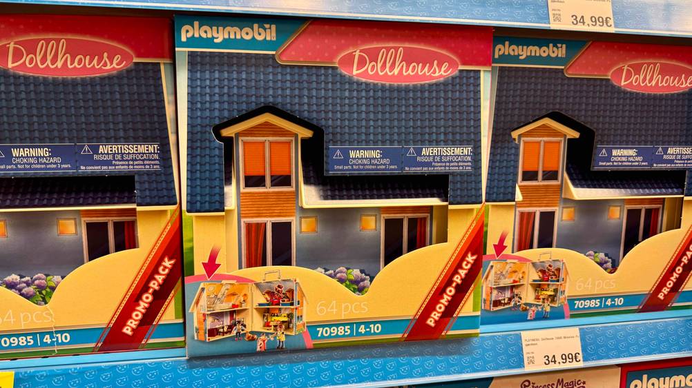 Mehrere getestete Playmobil-Häuser stehen in einem Regal, während auch das Preisschild ersichtlich ist.