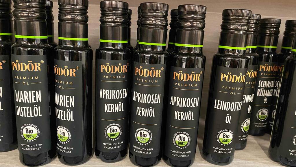 Aprikosenkernöl getestet: Eine Flasche steht neben mehreren auf einem Regal.