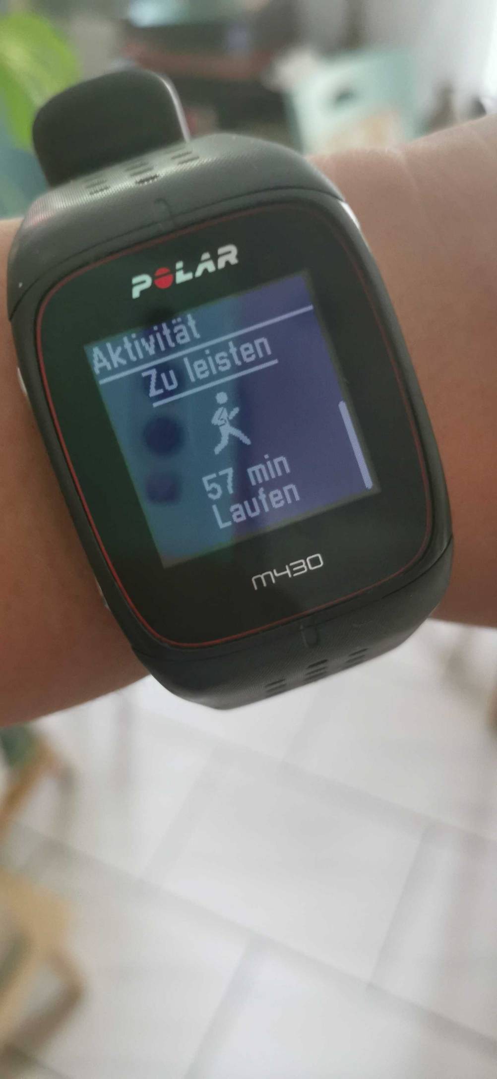 An einem Handgelenk befindet sich eine getestete Polar-Fitnessuhr mit eingeschaltetem Monitor.