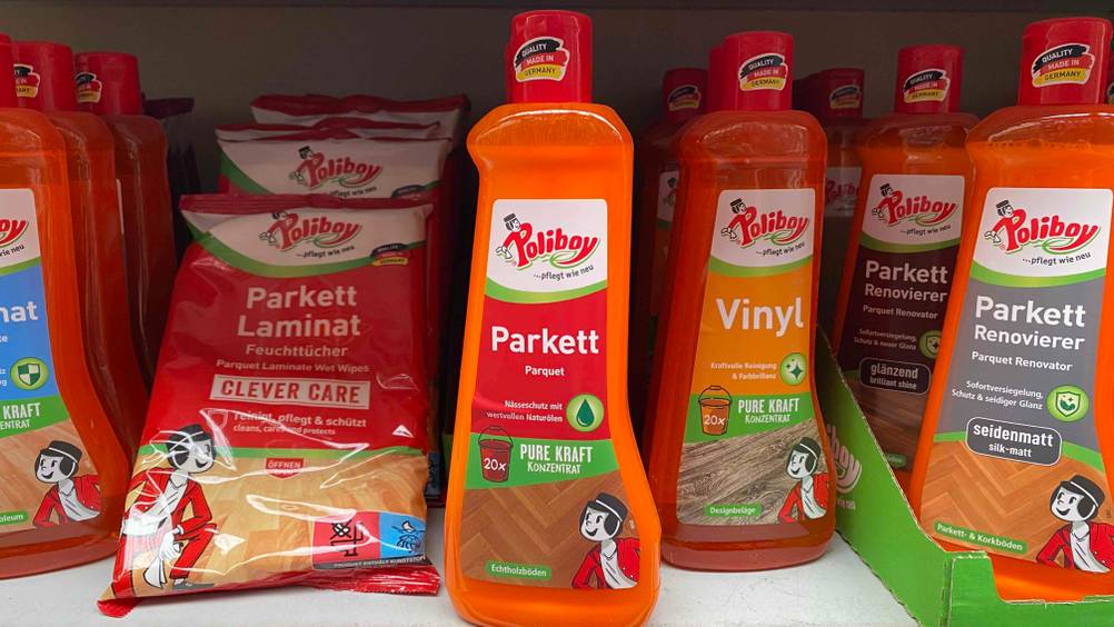 In einem Regal steht neben anderen Produkten eine Flasche Parkett Reiniger
