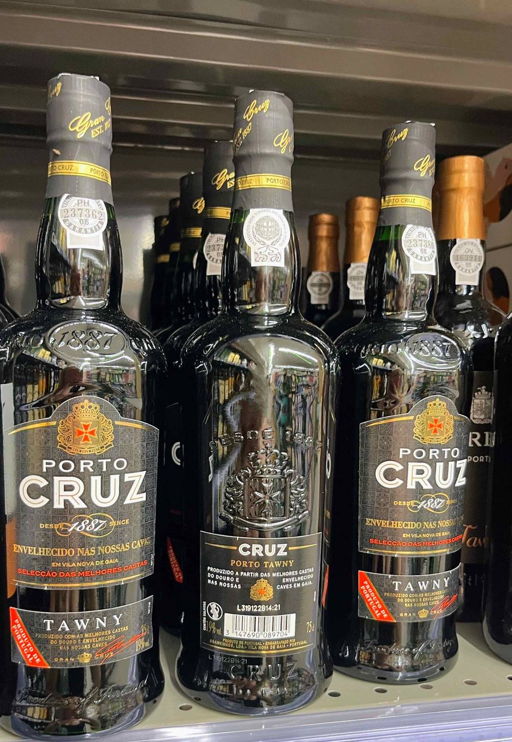 Portwein im Test: Mehrere Flaschen Portwein in einem Regal eine Flasche ist umgedreht