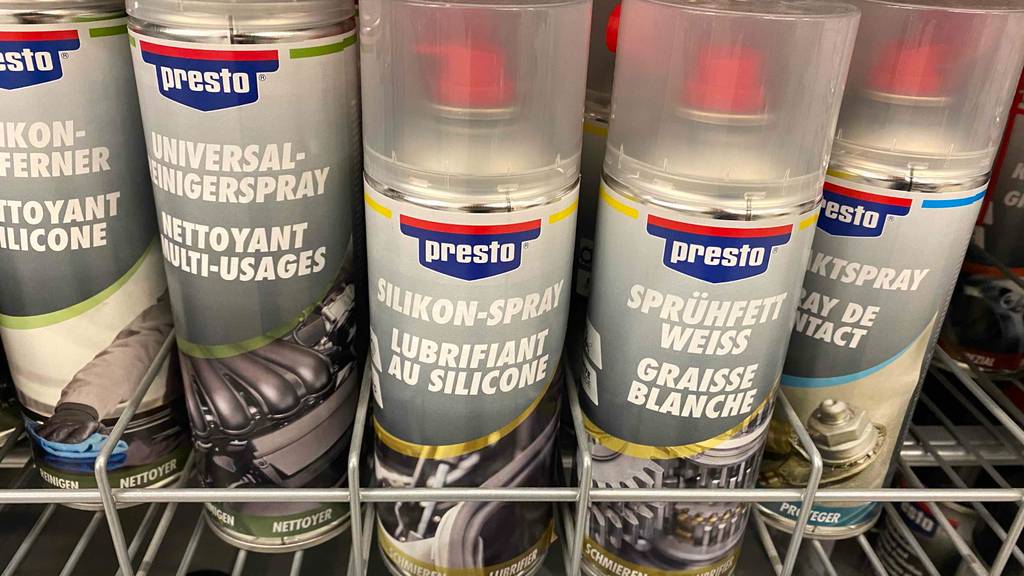 Silikonspray getestet: Silikonsprays in einem Regal stehend neben anderen Produkten.