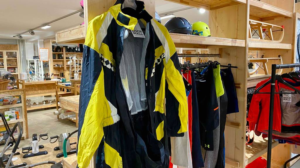 Motorrad-Regenkombi getestet: eine Motorrad-Regenkombi hängt in einem Geschäft auf einem Kleiderbügel, im geöffneten Zustand.