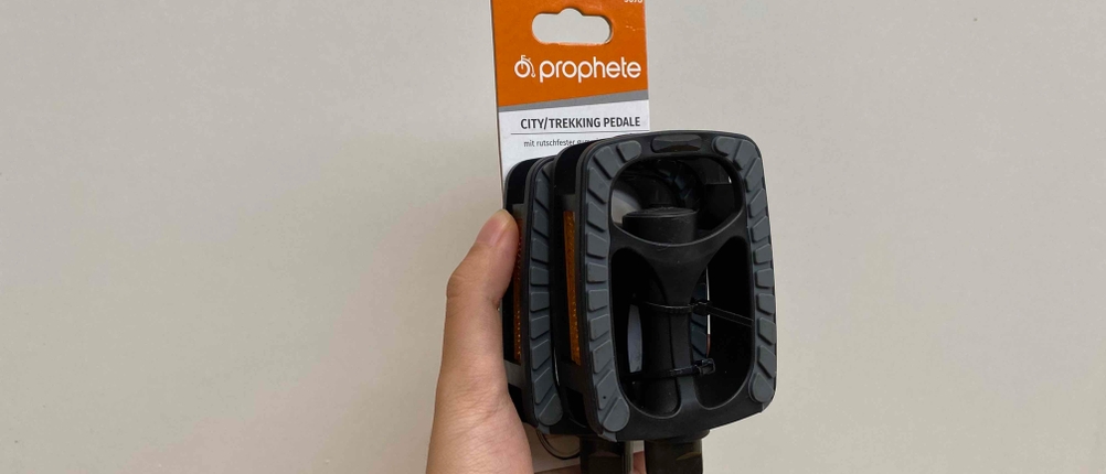 Getestete Fahrradpedalen werden mit der Hand vor einer weißen Wand gehalten