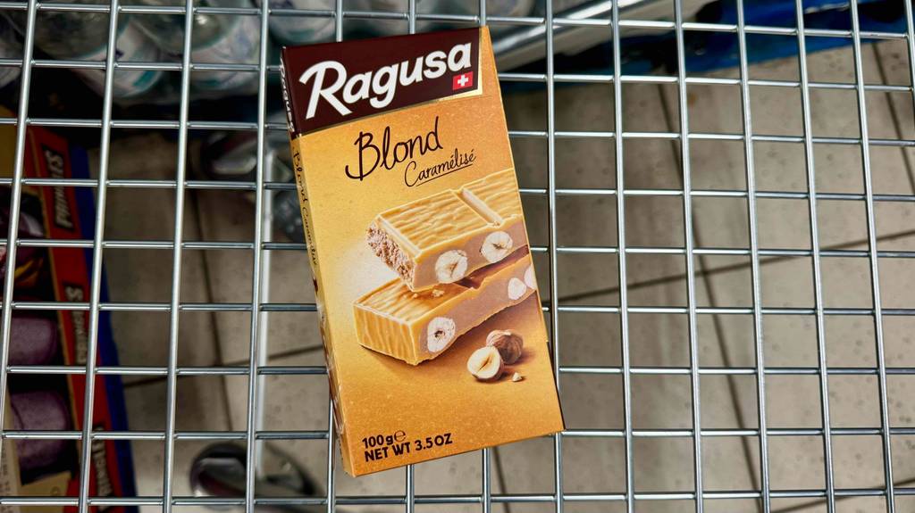 Eine Tafel der getesteten schweizer Schikolade liegt in einem Einkaufswagen.