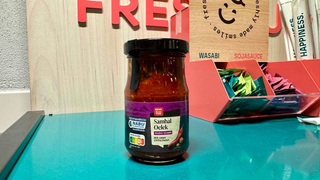 Ein Glas getestetes Sambal-Oelek steht auf einem Tisch mit Wasabi und Sojasauce.