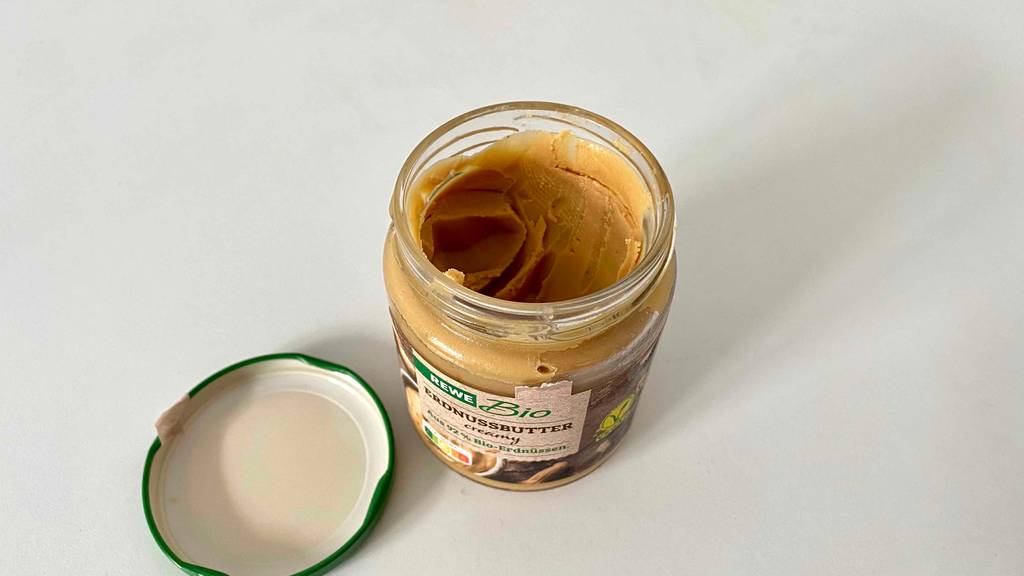 Offenes Erdnussbutterglas mit Deckel