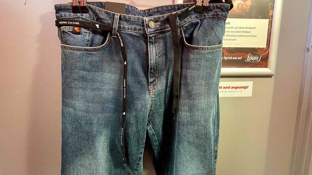 Motorradjeans getestet: eine Motorradjeans mit Schnüren darin, ist auf einem Kleiderbügel befeseigt.