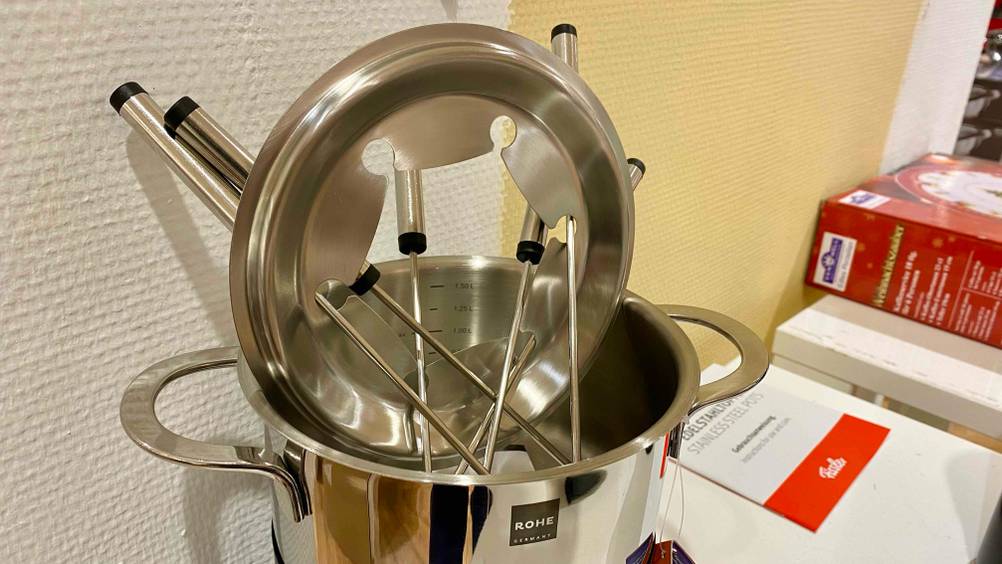 Ein getestetes Fondue mit abgenommenem Deckel und Spießen.