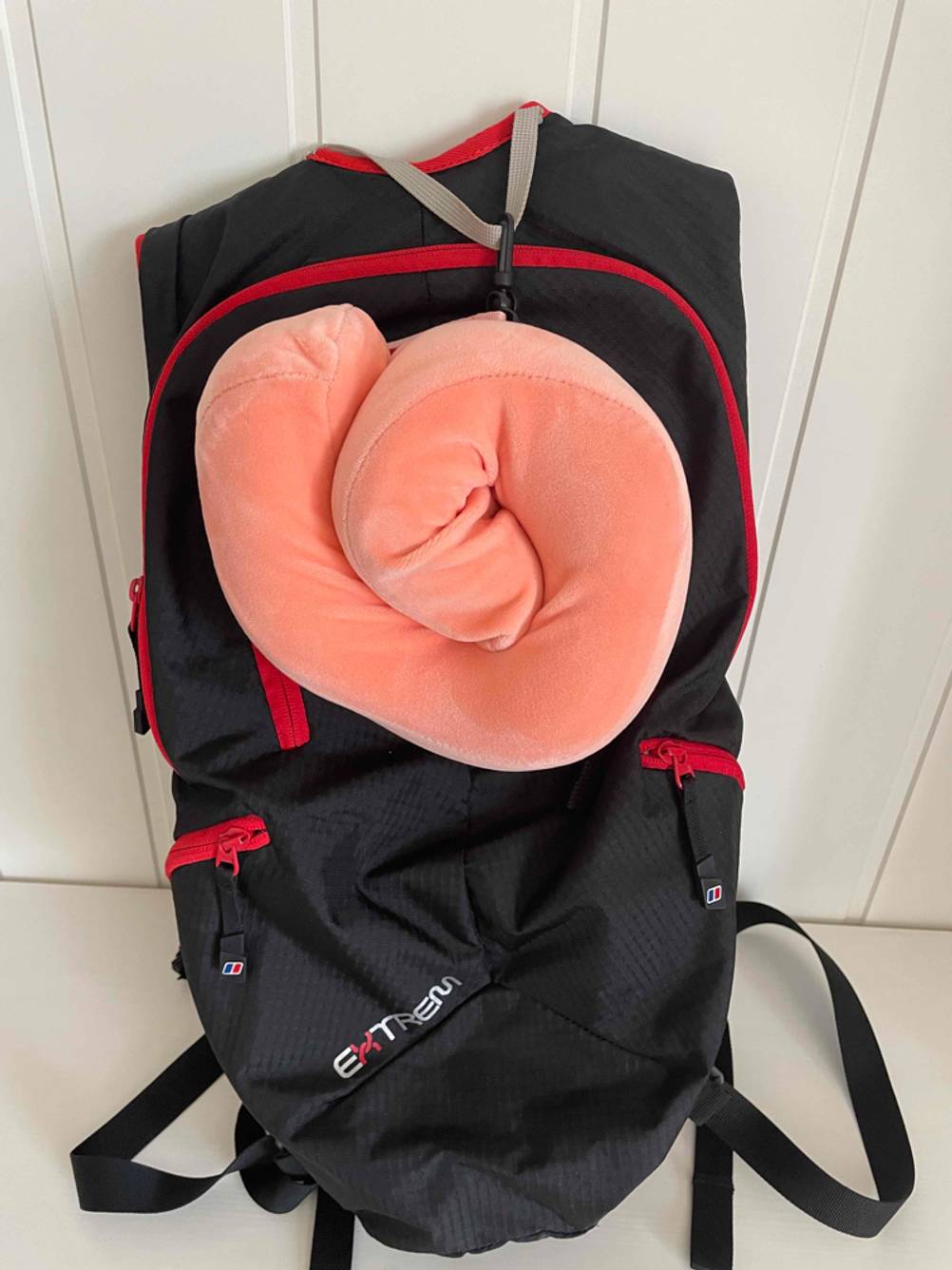 Ein getestetes Reisekissen zusammengerollt an einer Reisetasche.
