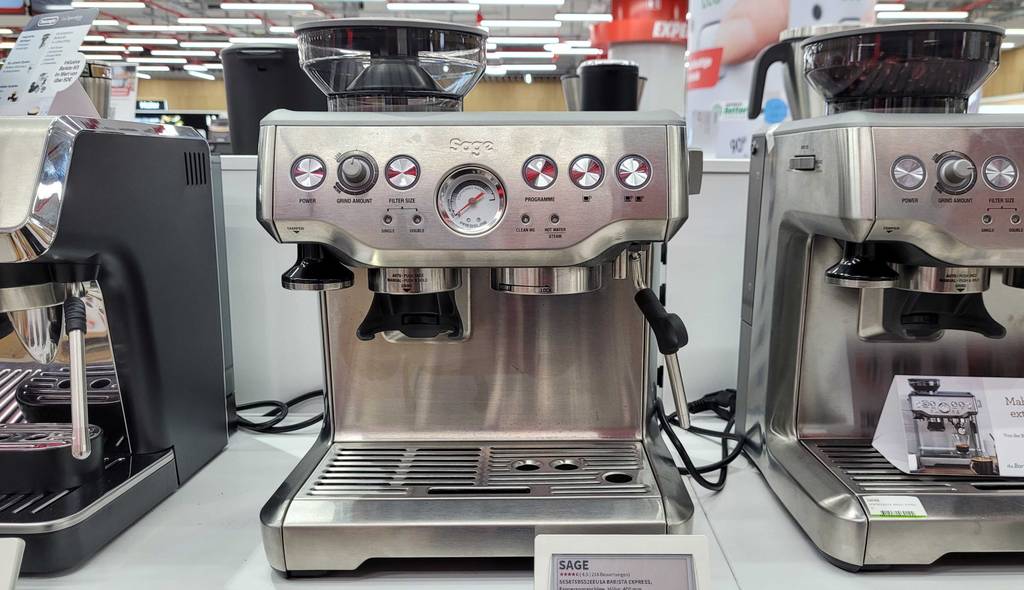 Eine getestete Sage-Espressomaschine von vorne auf einer hellen Oberfläche neben anderen.